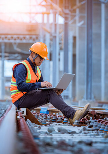 Engineer under inspection and checking construction process railway switch and checking work on railroad station by notebook .Engineer wearing safety uniform and safety helmet in work.